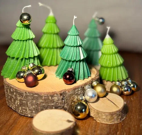 Kerzen in Form von Weihnachtsbäumen mit Weihnachtsdeko