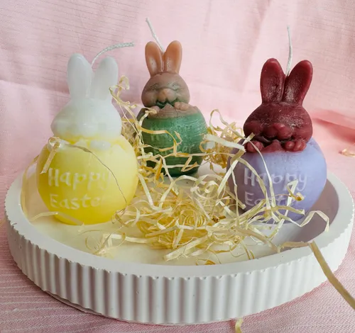 Drei Eiförmige Kerzen, aus denen (warum auch immer) Osterhasen schlüpfen